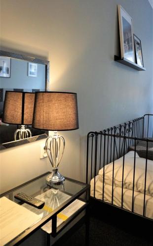 a hotel room with a bed and a table with a lamp at Expolis Residence - City Center - 24h POZNAŃ GŁÓWNY #betterthanyourEX in Poznań