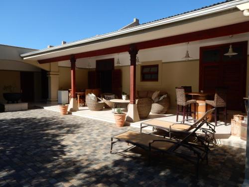 a patio with chairs and tables on a house at The Courtyard at La Loggia in Nottingham Road
