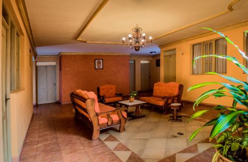 a lobby with chairs and a couch and a table at Hotel Monserrat in Cochabamba