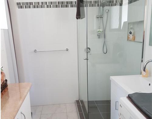 a shower with a glass door in a bathroom at Theme Park Getaway in Gold Coast