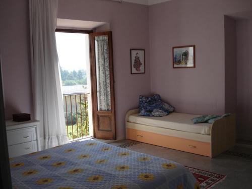 a bedroom with a bed and a window and a door at Abruzzo Segreto in Navelli