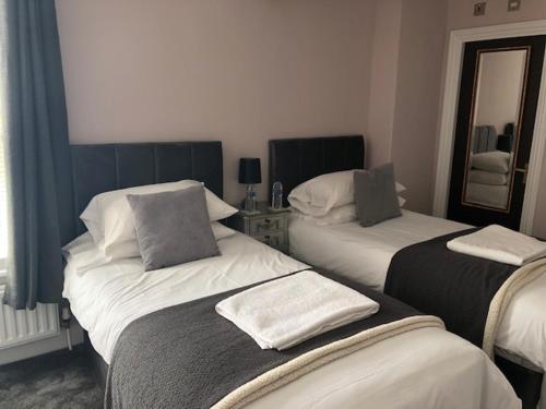 a hotel room with two beds and a mirror at Prince of Wales Marlow in Marlow