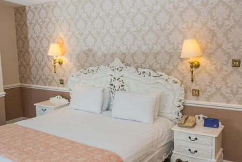 A bed or beds in a room at Manor Of Groves Hotel 