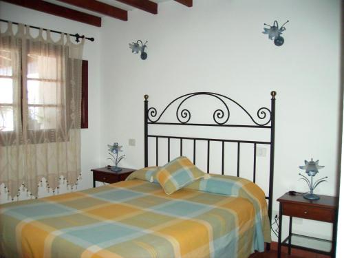 um quarto com uma cama e duas mesas e uma janela em Casa rural Antonio García em Jerez de la Frontera