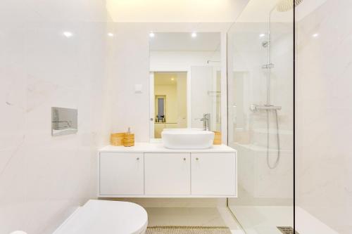 a white bathroom with a sink and a shower at Wood Premium Downtown Apartment by DA'HOME in Porto
