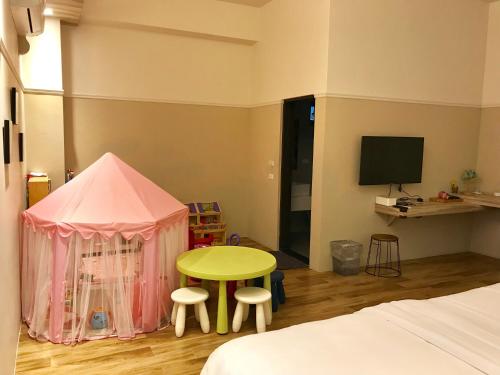 a bedroom with a pink tent and a table and stool at 茶田關舍民宿Tea Paddy B&B in Guanshan