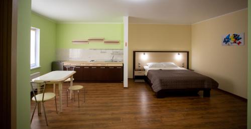 a bedroom with a bed and a table and a kitchen at Hotel Complex Olimp in Uman