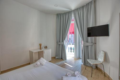 ナポリにあるB&B Filangieriのベッドルーム(ベッド1台、テレビ、窓付)