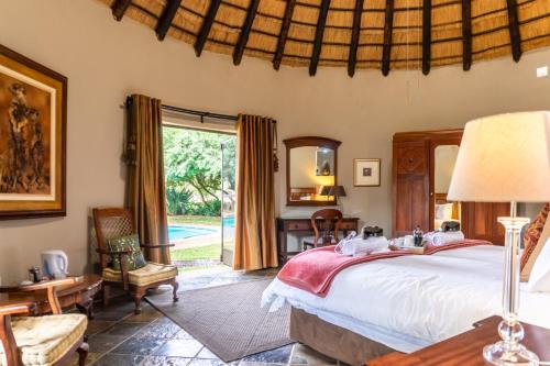 a bedroom with a bed and a large window at Re a Lora Lodge in Bela-Bela