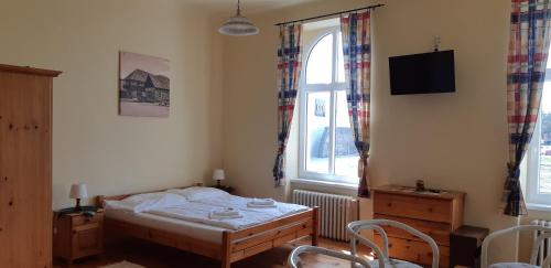 a small bedroom with a bed and a window at Victoria - Penzion & Restaurant in Zvolen