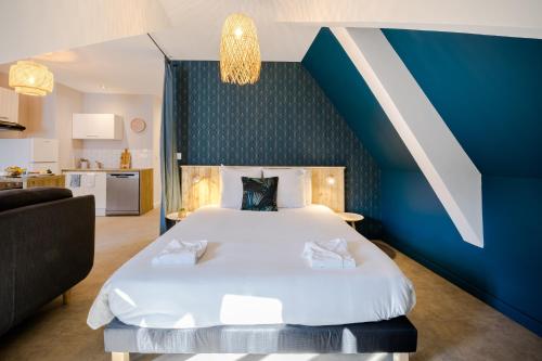 - une chambre avec un grand lit et un mur bleu dans l'établissement Appartements Le Bleu des Roches Noires, à Saint-Gilles les Bains