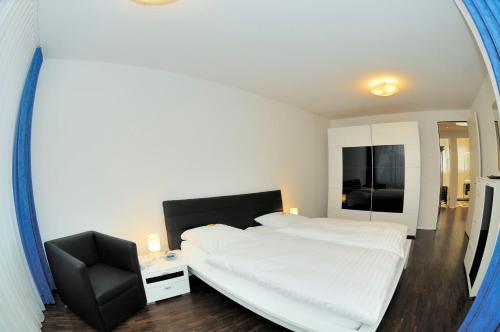 a bedroom with a bed and a chair and a mirror at PABS Résidences - Florastrasse 28 (5L) in Zurich