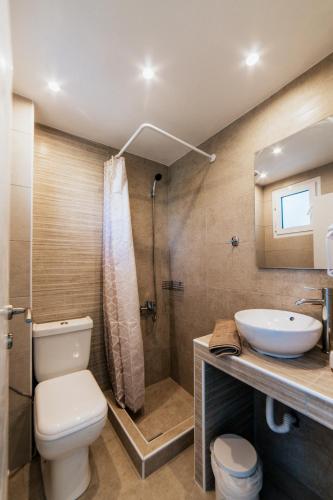 a bathroom with a toilet and a sink and a shower at Cyclades Luxury Studios in Nea Potidaea