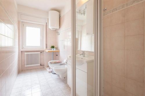 a white bathroom with a toilet and a sink at Sun in Nago-Torbole