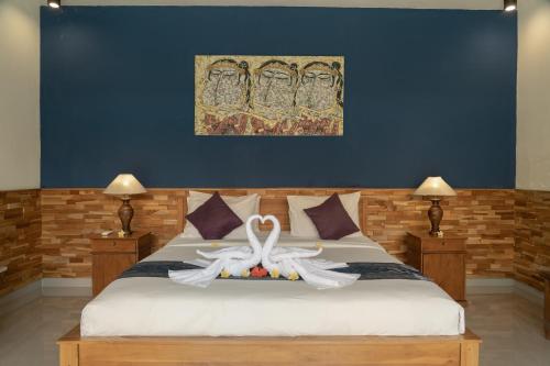 a bedroom with a bed with two swans on it at Ubud Lestari Villa in Ubud