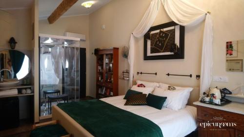 1 dormitorio con 1 cama grande con manta verde en EpicuRooms - Maison d'Hôtes Romantique - Chambres à thème, en Gallargues-le-Montueux