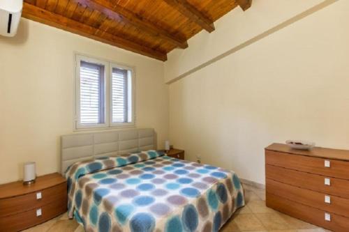 una camera con letto, cassettiera e finestra di casavera ad Avola