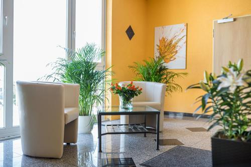 a lobby with two chairs and a table with plants at Europa Hotel Garni free parking in Fürth