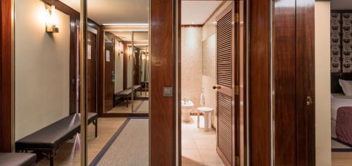 a corridor of a hotel room with chairs and a bed at Algarve Casino Hotel in Portimão