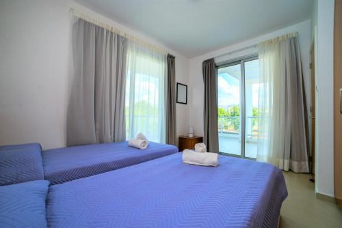 a bedroom with two beds and a large window at Coral Bay Villa 10 in Coral Bay