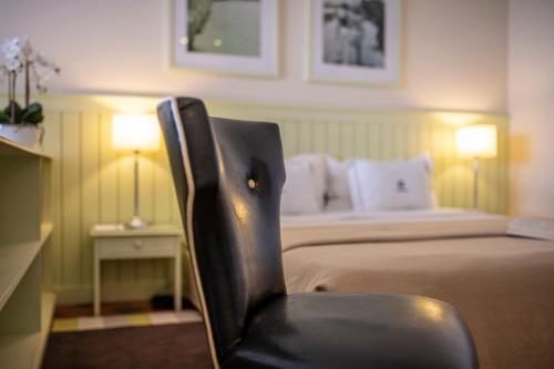 a bedroom with a bed and a black chair at Algarve Casino Hotel in Portimão