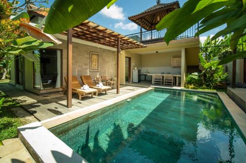 a swimming pool in a backyard with a villa at Ubud Lestari Villa in Ubud