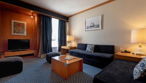 a living room with a couch and a tv at Algarve Casino Hotel in Portimão