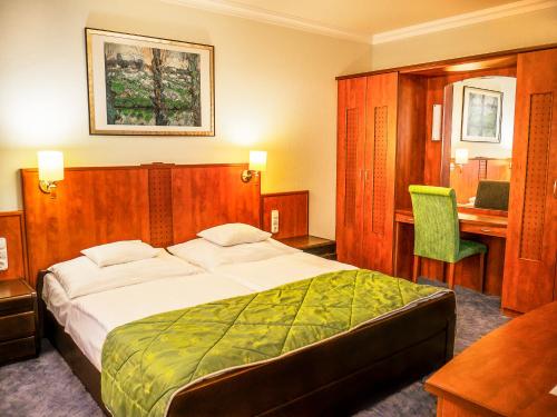 a hotel room with a bed and a desk at Hotel Silver in Hajdúszoboszló