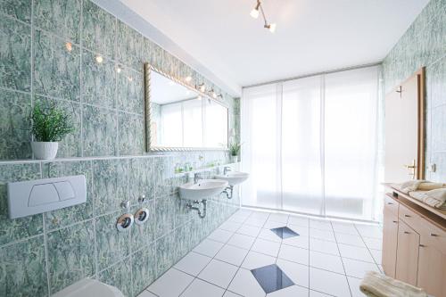 baño con lavabo, 2 lavabos y espejo en Europa Hotel Garni, en Fürth