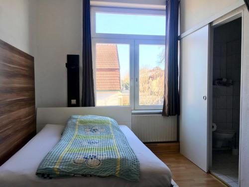 ein Schlafzimmer mit einem Bett und einem großen Fenster in der Unterkunft Pension Akropolis in Rellingen