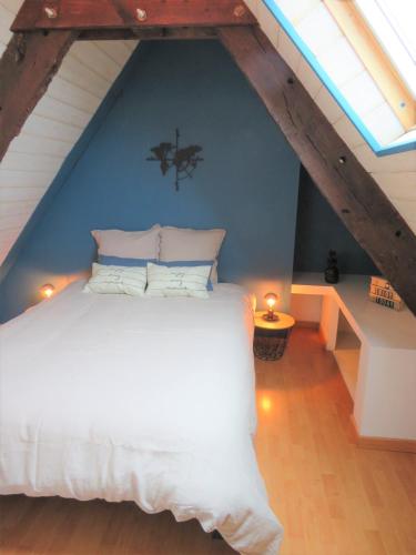 une chambre avec un lit blanc dans un grenier dans l'établissement Duplex Saint Malo Saint Servan plage à 100m Intra Muros à 7min à pied, à Saint-Malo