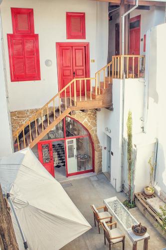 a house with red doors and a staircase and an umbrella at NICOSIA EAGLE EYE in North Nicosia