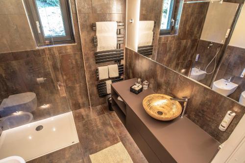 un bagno con lavandino, WC e vasca di Montanara Chalet a Fai della Paganella