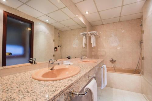 a bathroom with two sinks and a tub at Yomo Imperial in Sant Julià de Lòria