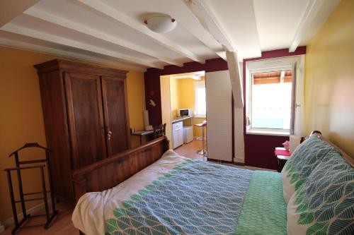 a bedroom with a bed with a wooden headboard and a window at La chambre aux hirondelles in Ittenheim