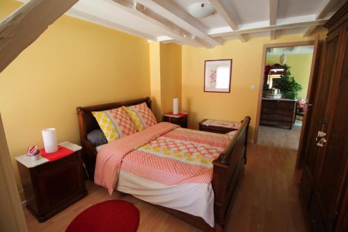 a small bedroom with a bed and a mirror at La chambre aux hirondelles in Ittenheim