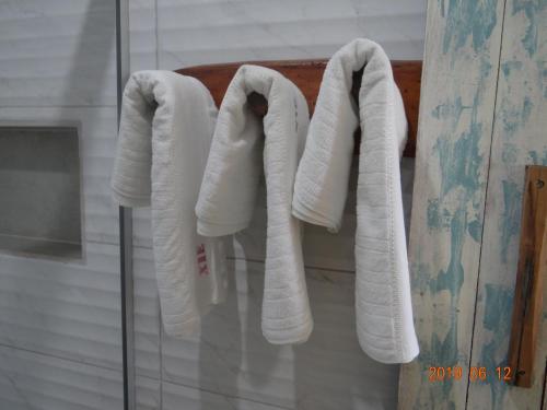 a group of towels hanging on a rack in a bathroom at Chalés XIÉ in São Miguel dos Milagres