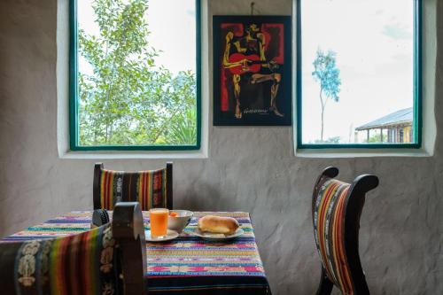 a table with a plate of food and a sandwich on it at Hostería Colibri Aeropuerto in Tababela