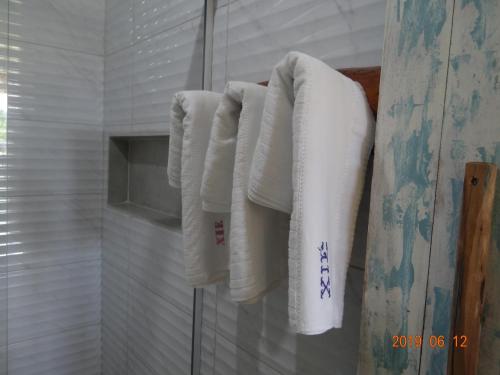 a group of towels hanging on a wall in a bathroom at Chalés XIÉ in São Miguel dos Milagres