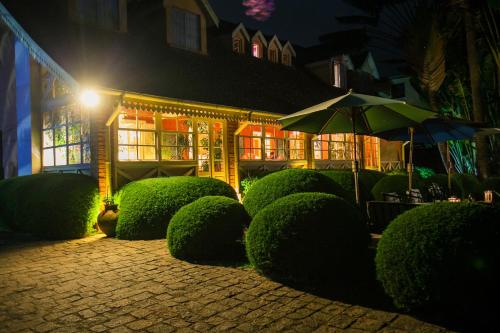 a house with hedges and an umbrella at night at Tsara Guest House in Fianarantsoa