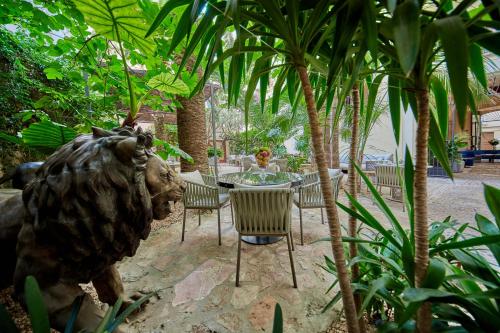 Palacio Can Marqués by Puro في بالما دي ميورقة: طاولة وكراسي في حديقة بها تمثال