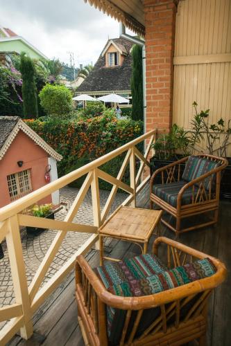 a wooden deck with chairs and a table and a table at Tsara Guest House in Fianarantsoa