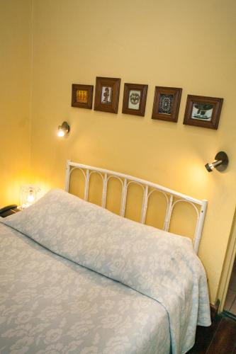 a bedroom with a white bed with pictures on the wall at Tsara Guest House in Fianarantsoa