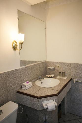 a bathroom with a sink and a mirror and a toilet at Tsara Guest House in Fianarantsoa