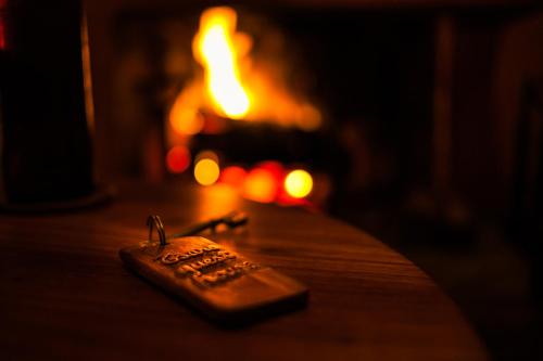 a remote control sitting on a table in front of a fireplace at Tsara Guest House in Fianarantsoa
