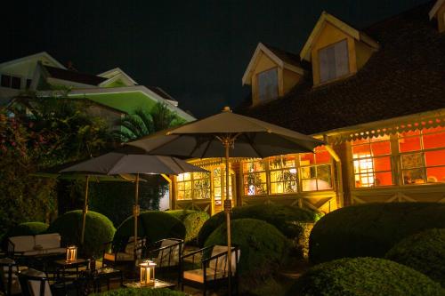 a house with tables and umbrellas in front of it at night at Tsara Guest House in Fianarantsoa