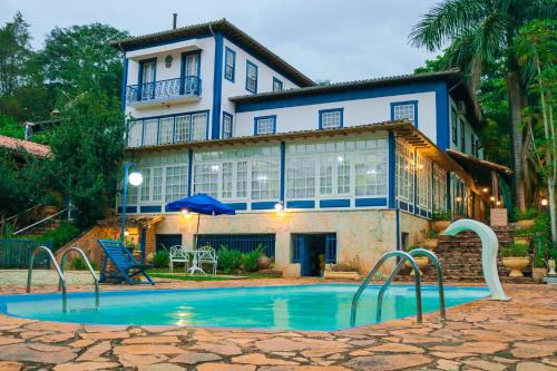 une maison avec une piscine en face d'une maison dans l'établissement Pousada Xica da Silva, à Tiradentes