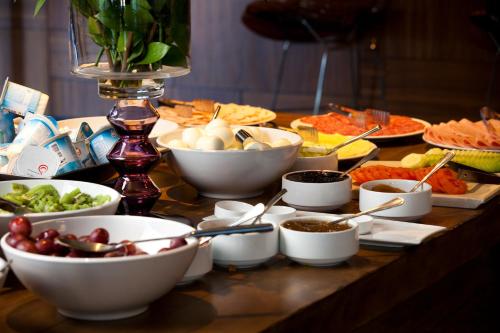 a table topped with bowls and plates of food at Wyndham Santiago Pettra in Santiago