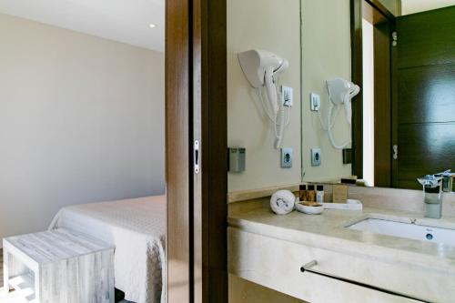 Baño del hotel con lavabo y espejo en Hotel Boutique Aroma de Mar, en Chiclana de la Frontera