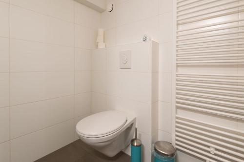 uma casa de banho branca com um WC e um chuveiro em Quiet apartment for 4 at park in center em Amsterdã